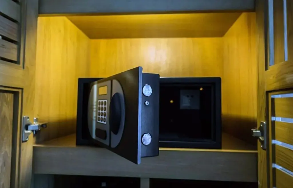 Coffre-fort électronique encastré ouvert dans une armoire en bois, utilisé pour la sécurisation des objets de valeur et documents sensibles.